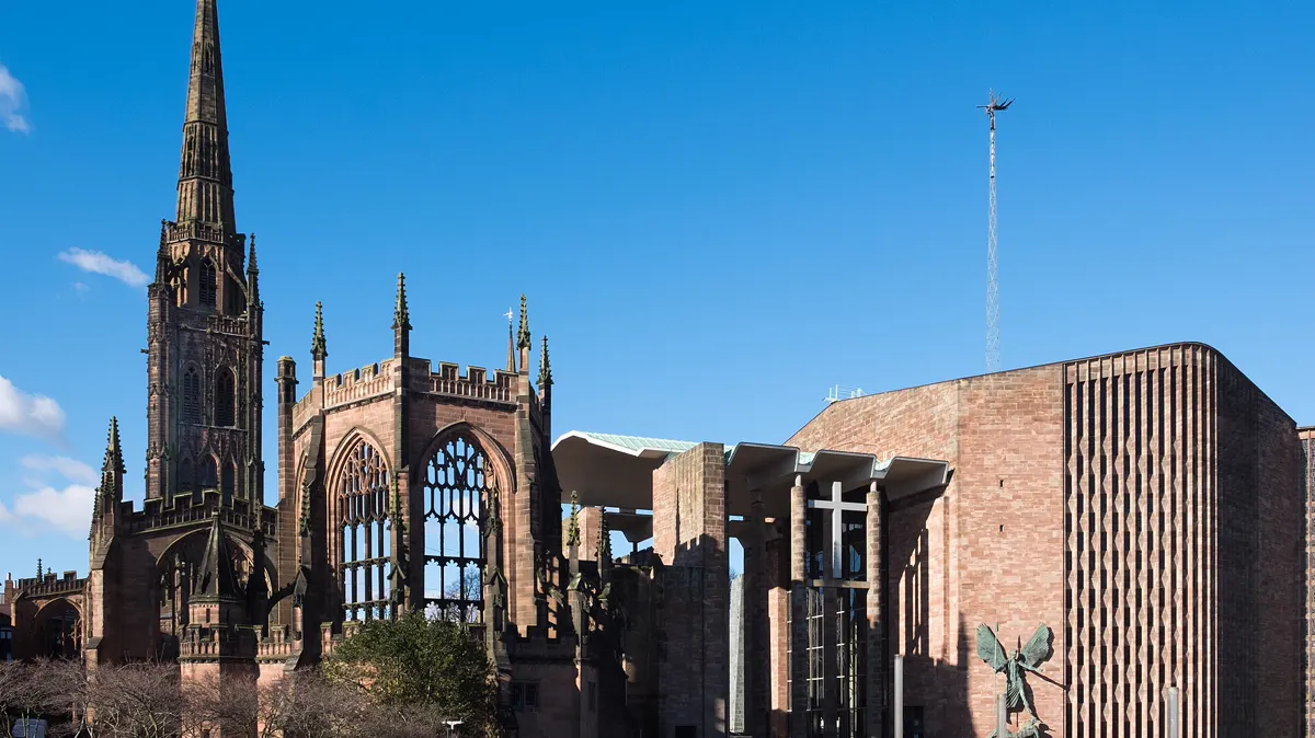 Coventry Cathedral: the spire of the old cathedral ruins beside the modern cathedral under a blue sky